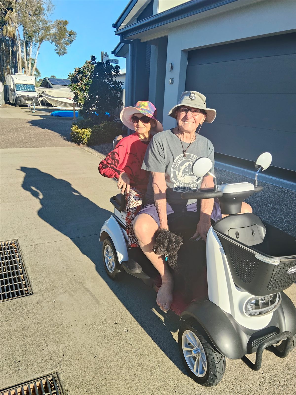 Two customers and their dog enjoying a white ROVA Metro mobility scooter