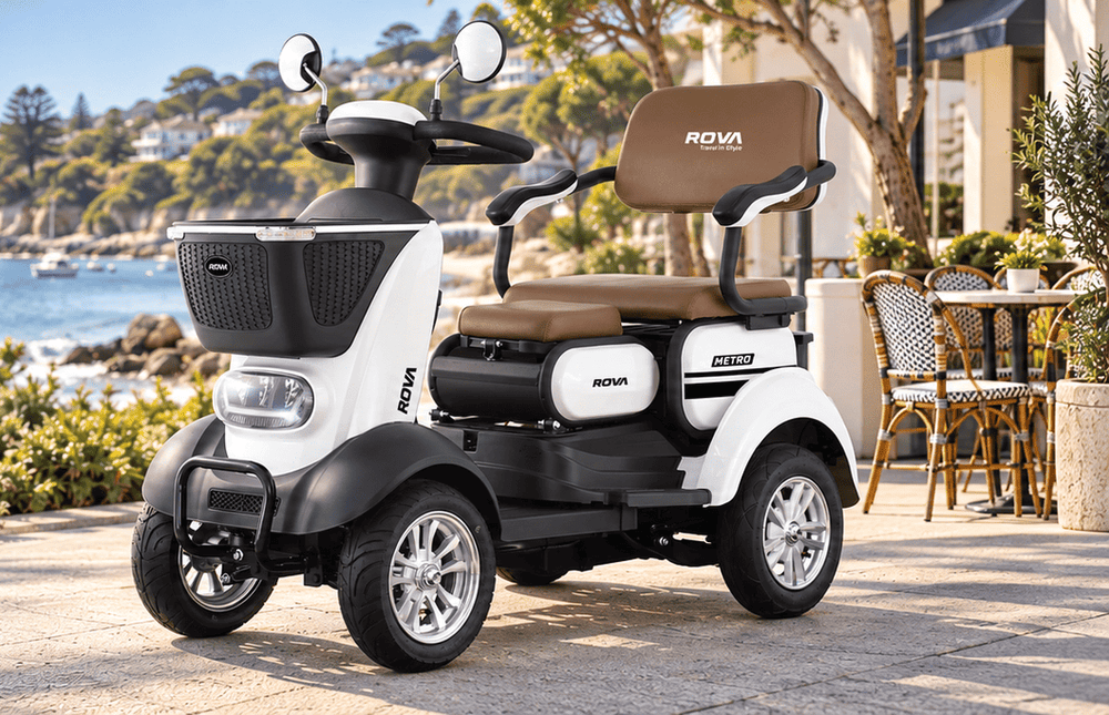 White ROVA Metro scooter beside a coastal cafe